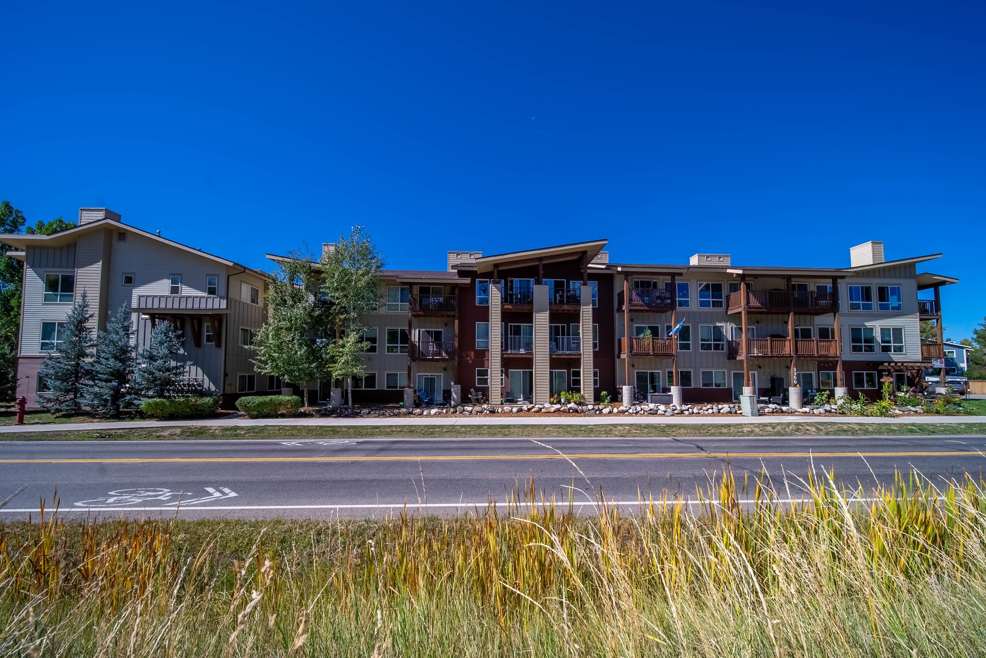 A row of modern apartment buildings with a clear blue sky above.